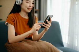 Woman using smart phone for mobile payments online shopping, omni channel, sitting on table, virtual icons graphics interface screen photo