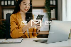 Asian Woman hands using Laptop, tablet typing on keyboard and surfing the internet with email icon, email marketing concept, send e-mail or newsletter, online working internet network technology. photo