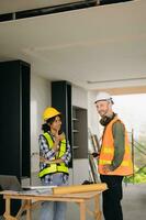 Architect caucasian man and woman working with colleagues mixed race in the construction site. Architecture engineering on big project. Building in construction process interior. photo