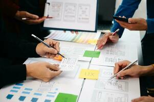 vista de cerca del equipo de desarrolladores de ui haciendo una lluvia de ideas sobre su proyecto con una computadora portátil, un teléfono inteligente y una tableta digital. agencia creativa de desarrollo digital. foto