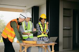 Architect caucasian man and woman working with colleagues mixed race in the construction site. Architecture engineering on big project. Building in construction process interior. photo