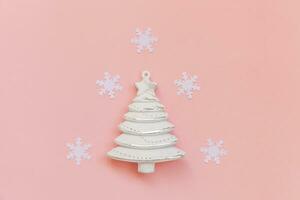 Simply minimal composition winter objects ornament fir tree snowflakes isolated on pink pastel trendy background photo