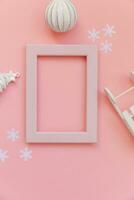 Simply minimal composition winter objects pink frame ornament fir tree sled isolated on pink pastel trendy background photo