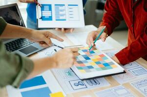 UX developer and ui designer brainstorming about mobile app interface wireframe design with customer breif and color code at office. photo