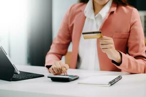 Woman using smart phone for mobile payments online shopping, omni channel, sitting on table, virtual icons graphics interface screen photo