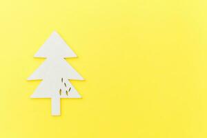 Simply minimal composition winter objects ornament fir tree isolated on yellow trendy background photo