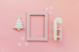 Simply minimal composition winter objects pink frame ornament fir tree sled isolated on pink pastel trendy background photo