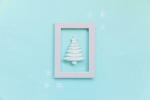 Simply minimal composition winter objects ornament fir tree in pink frame isolated on blue pastel trendy background photo