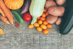 Assortment different fresh organic vegetables on country style wooden background. Healthy food vegan vegetarian dieting concept. Local garden produce clean food. Frame top view flat lay copy space. photo