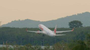 Phuket, Thailand November 26, 2019 - - thailändisch Löwe boeing 737 Abfahrt von Phuket Flughafen, wolkig Himmel Hintergrund. Aussicht von das oben Fußboden von das Spritzen Strand Resort Hotel, Phuket, Thailand video