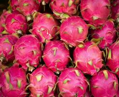 fresh dragon fruit background, pile of pink dragon fruit  fruit in market. A pitaya or pitahaya is the fruit of several different cactus species  indigenous to the Americas. photo