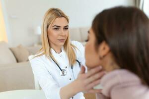 joven mujer sentado mientras el enfermero examinando su garganta. médico comprobación paciente tiroides glándula, salud examen en hospital foto