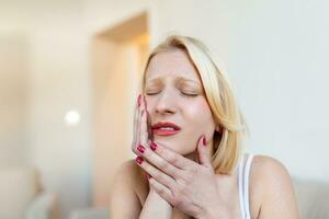 retrato de una mujer caucásica infeliz que sufre de dolor de muelas en casa. salud, salud dental y concepto de problema. foto de stock