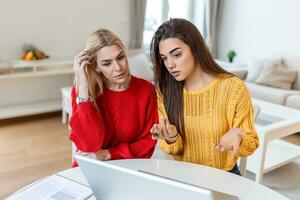 inteligente hembra estudiantes que se discute ideas para trabajo de curso proyecto leyendo información desde red en ordenador portátil computadora, joven mujer acecho tutorial juntos teniendo conversacion en oficina foto