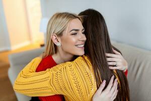 Candid diverse girls best friends embracing standing indoors, close up satisfied women face enjoy tender moment missed glad to see each other after long separation, friendship warm relations concept photo