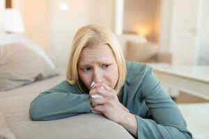 Unhappy young woman covering face with hands, crying alone close up, depressed girl sitting on couch at home, health problem or thinking about bad relationships, break up with boyfriend, divorce photo