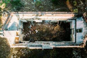 Drone aerial scenery of an abandoned building in the forest. Rooftop of a deserted house photo