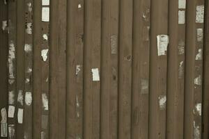 Wooden wall or fence with poster remnants photo