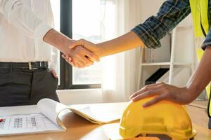 Construction worker team hands shaking greeting start up plan new project contract in office center at construction site, industry ,architecture, partner, teamwork, agreement, property, contacts. photo