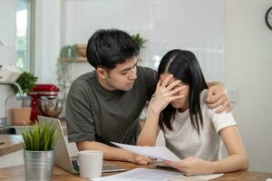 Stress and headache asian couple with large bills no money to pay to expenses and business problem. Husband encourage wife for problem on cafe, Financial problem, mortgage, loan, bankruptcy, poor photo