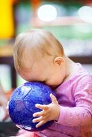 linda pequeño bebé jugando con un pelota foto