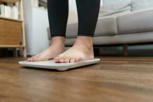Fat diet and scale feet standing on electronic scales for weight control. Measurement instrument in kilogram for a diet control. photo