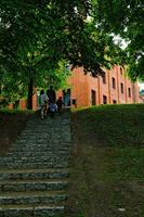 Polish historic brick palace in Rzucewo surrounded by summer greenery photo