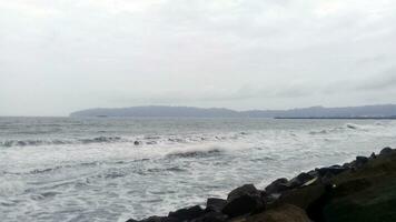 ver de el olas y rocas en el playa foto