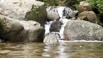 Close-up view of clear water cascading down river rocks photo