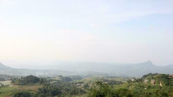 View of a mountain covered in mist and clear clouds photo