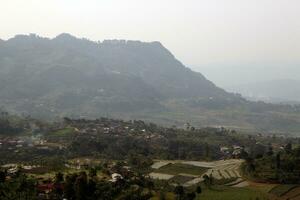 View of a mountain covered in mist and clear clouds photo