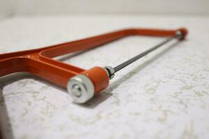 Close-up of orange hacksaw photo