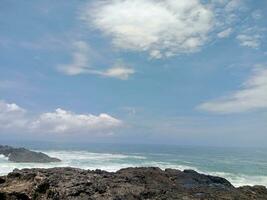 ver de el olas y rocas en el playa foto