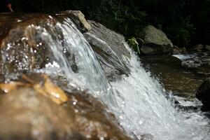 Close-up view of clear water cascading down river rocks photo