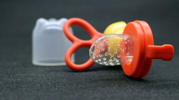 Orange baby pacifier with lid photo