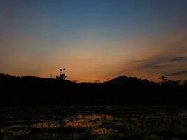 View of the beautiful blue and orange sky and the silhouette of a hill photo