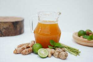 Ginger juice with fresh ginger and lemon on white background. Healthy drink. photo
