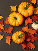 Autumn composition with pumpkins and leaves on dark background. Flat lay, top view. photo