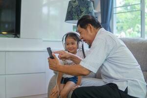 Grandfather and grandson playing video game at sofa. photo