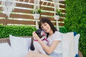 Young woman playing with her dog on sofa at home. photo