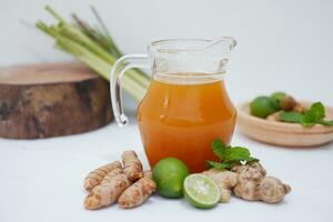 Ginger juice with fresh ginger and lemon on white background. Healthy drink. photo