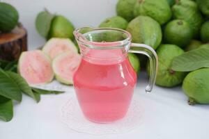 Fresco guayaba jugo en un vaso y Fresco guayaba fruta. foto