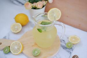 Lemonade with fresh lemon and mint leaves on a white background photo