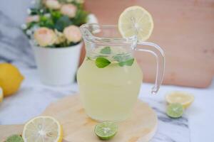 Lemonade with fresh lemon and mint leaves on a white background photo