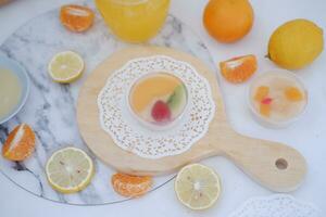 Fruit jelly with orange juice, lemon and kiwi on the table photo