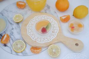 Fruta jalea con naranja jugo, limón y kiwi en el mesa foto