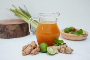Ginger juice with fresh ginger and lemon on white background. Healthy drink. photo
