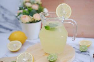 Lemonade with fresh lemon and mint leaves on a white background photo