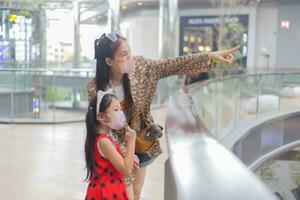 Mother and daughter looking something in shopping center. photo