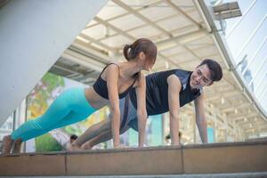 ajuste hombre y hermosa mujer practicando yoga al aire libre en el ciudad. foto